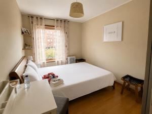 a small bedroom with a white bed and a window at Porto Nest in Senhora da Hora