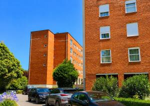 a red brick building with cars parked in front of it at Porto Nest in Senhora da Hora