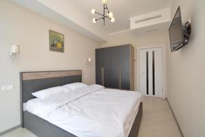 a bedroom with a white bed and a tv at Domel Tsaghkadzor in Tsaghkadzor