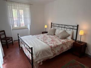 a bedroom with a bed and two lamps and a window at Casa Spaziosa Vista Castello - 3minuti dal Centro di Barolo in Barolo