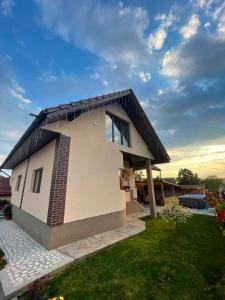 a small house with a black roof at Pensiunea CAV in Novaci-Străini