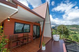 a home with a balcony with a view of the mountains at Leesuma Homestay in Ban San Pu Loei