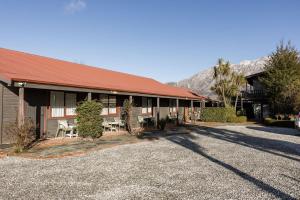 a building with a red roof with a table and chairs at #2 Glenorchy Alpine Suite in Glenorchy