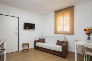 a living room with a chair and a tv on the wall at Habitaciones Martín in San José