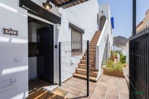 a house with a balcony with a gate and stairs at Habitaciones Martín in San José