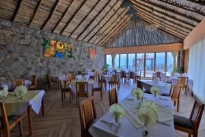 a restaurant with tables and chairs and a stone wall at Mezena Resort & SPA in Lalibela
