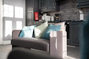 a couch with pillows on it in a kitchen at 4BR Mitchell Street Apartment Sleeps 6 by Stay With Us in Shield Row