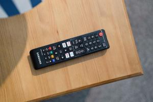 a remote control sitting on top of a wooden table at 4BR Mitchell Street Apartment Sleeps 6 by Stay With Us in Shield Row +38 photos
