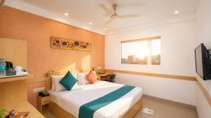 a hotel room with a bed and a television at Mango Grove Hotel in Chandīgarh