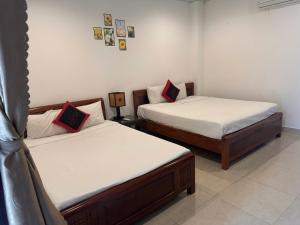 two beds in a small room with at Pham Gia Boutique Villa in Hoi An