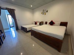 a bedroom with two beds and a window at Pham Gia Boutique Villa in Hoi An