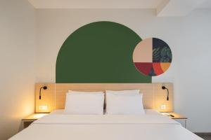 a bed with two white pillows and a green wall at Cove Limora in Bandung