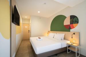 a hotel room with a bed and a television at Cove Limora in Bandung