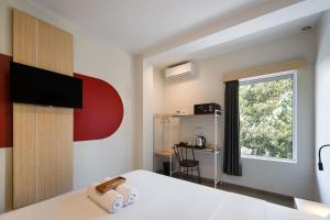 a room with a bed with a window and a desk at Cove Limora in Bandung +15 photos