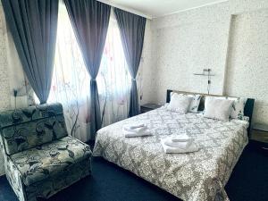a hotel room with a bed and a chair at Velonia Guest House in Sozopol