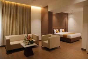 a hotel room with a bed and a couch and chairs at MOKSH SERENe in Shrīnagar +17 photos