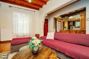 a living room with a red couch and a table at Eleas Gi Villa in Vitalades