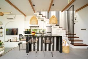 a kitchen with a staircase and a table and chairs at Villa Scorpia 1 Bingin in Bingin Beach