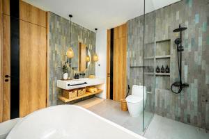 a bathroom with a tub and a toilet and a mirror at Villa Scorpia 1 Bingin in Bingin Beach +25 photos