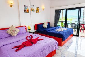 a bedroom with two beds with red bows on them at Antalya Hostel Bar & Restaurant in Kaôh Rŭng (3)