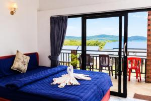 a bedroom with a blue bed and a balcony at Antalya Hostel Bar & Restaurant in Kaôh Rŭng (3)