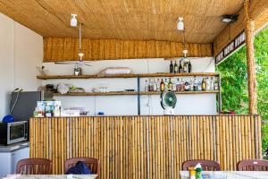 a kitchen with a wooden partition with tables and chairs at Antalya Hostel Bar & Restaurant in Kaôh Rŭng (3)