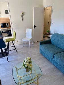 a living room with a blue couch and a glass table at Escale Berckoise Studio Cosy Proche des Phoques in Berck-sur-Mer +6 photos
