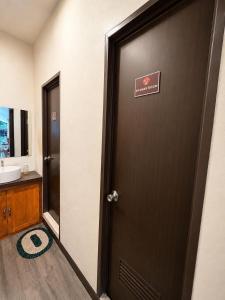 a bathroom with a door with a sign on it at Bayay Isla Inn in General Luna +9 photos