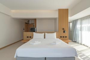 ein Schlafzimmer mit einem großen Bett mit weißer Bettwäsche in der Unterkunft Jace Ratchada Hotel in Bangkok