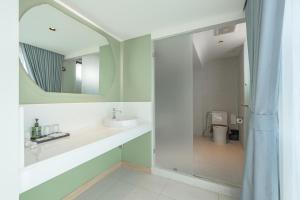 ein Badezimmer mit Waschbecken und Spiegel in der Unterkunft Jace Ratchada Hotel in Bangkok + 43 Fotos