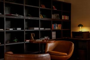 a room with a table and a chair and book shelves at Yuhigaura Onsen Ryotei KAI in Kyotango