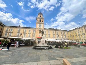 a large building with a clock tower in front of it at Garibaldi Living - Centro Storico Parma in Parma