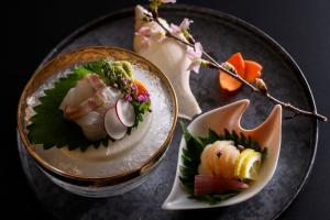 two plates of food sitting on a table with food at Yuhigaura Onsen Ryotei KAI in Kyotango +92 photos