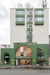 ein weiß-grünes Gebäude mit einem Jase-Laden in der Unterkunft Jace Ratchada Hotel in Bangkok