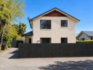 ein Haus mit einem schwarzen Zaun davor in der Unterkunft Snow Fed House in Methven