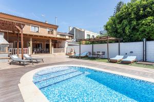 a swimming pool in front of a house at Marenostrum Villa in Valencia