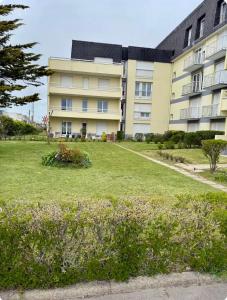 a large building with a lawn in front of it at Escale Berckoise Studio Cosy Proche des Phoques in Berck-sur-Mer