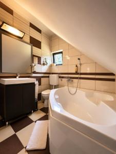 ein Badezimmer mit Badewanne, Toilette und Waschbecken in der Unterkunft Garden Retreat in Bran + 116 Fotos