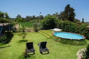 a yard with two chairs and a swimming pool at Eleas Gi Villa in Vitalades