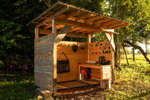 a wooden out house with a stove in the grass at Countryside yurt near Tõrva in Jõgeveste +29 photos