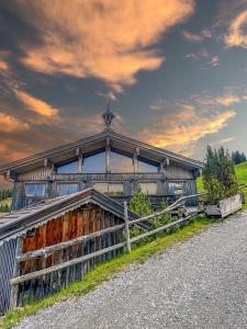 an old building with a fence in front of it at Alm Chalet - Au Hochalm in Söll