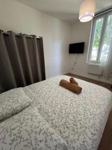 a bedroom with a bed with a teddy bear on it at Chambre privée in Vénissieux