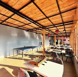 a room with tables and ping pong tables at Orchard Valley Resort in Mai Jūbar
