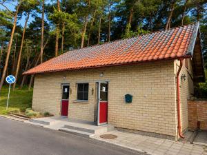 a small brick building with an orange roof at Garuda yacht in Nida