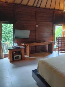 a bedroom with a bed and a bench in a room at Sri Abi Ratu Villa in Sukawati