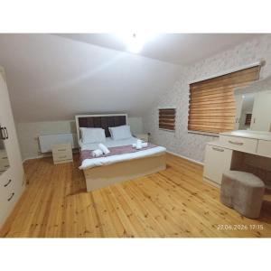 a bedroom with a bed and a wooden floor at Qəbələn SNS RENTAL VILLA in Gabala