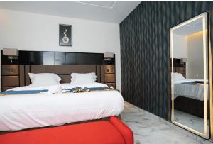a bedroom with a large bed and a mirror at Oxvera Hotel Limited in Umuahia