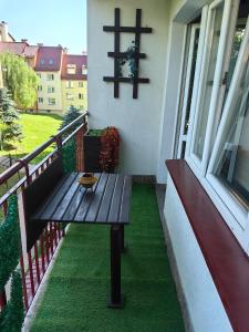 a wooden bench sitting on the balcony of a house at Zielony Balkon in Sanok