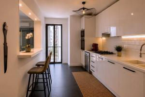 a kitchen with white cabinets and a sink and a counter at Luxe-Design Imperio II- Petit Déjeuner 5min de la Mer in Praia