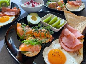 a plate of food with eggs and meat and vegetables at Manas Guesthouse in Benalla
